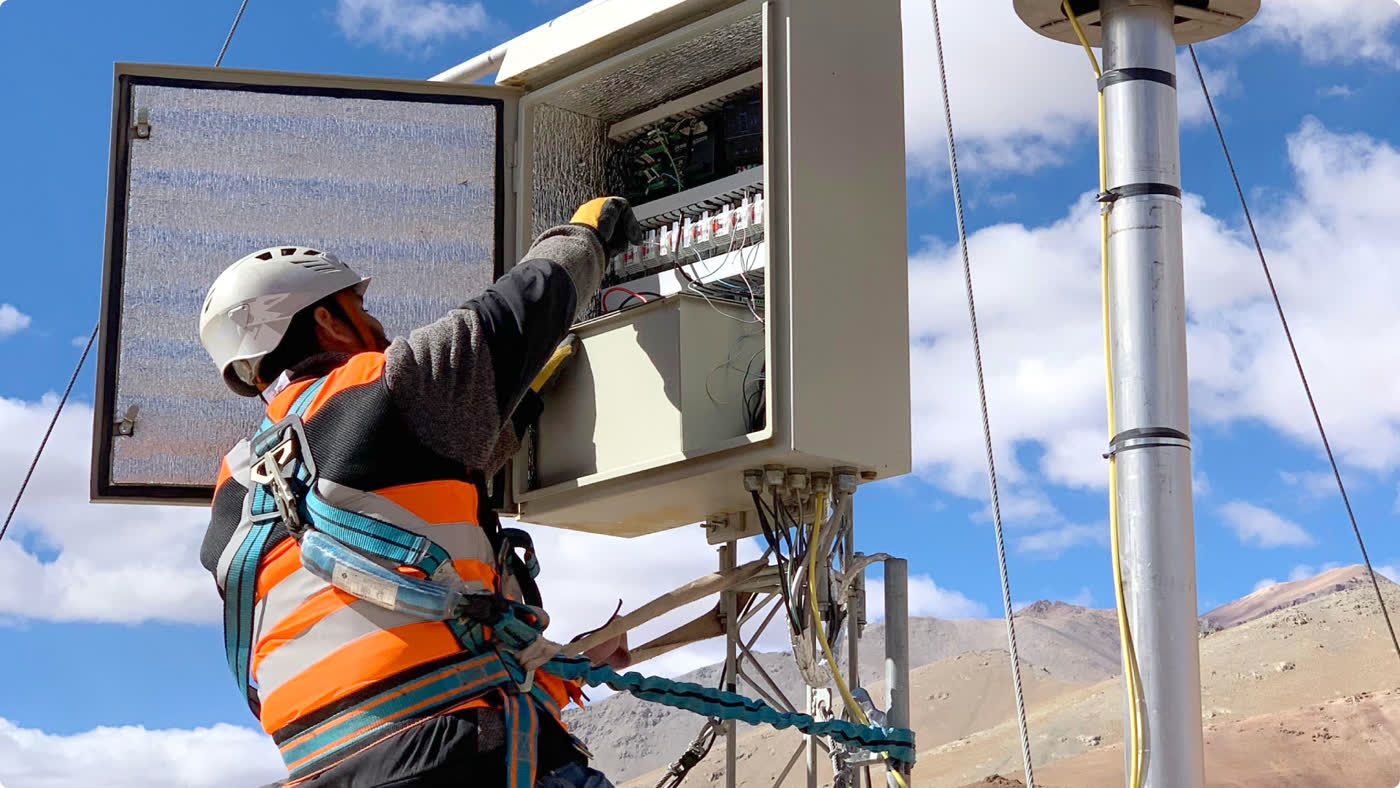 GHM technician working at an equipment station in the Andes